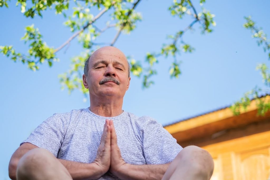 Homme sénior en pleine méditation pour son bien-être mental